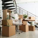 Cardboard,boxes,and,furniture,near,stairs,in,office.,moving,day