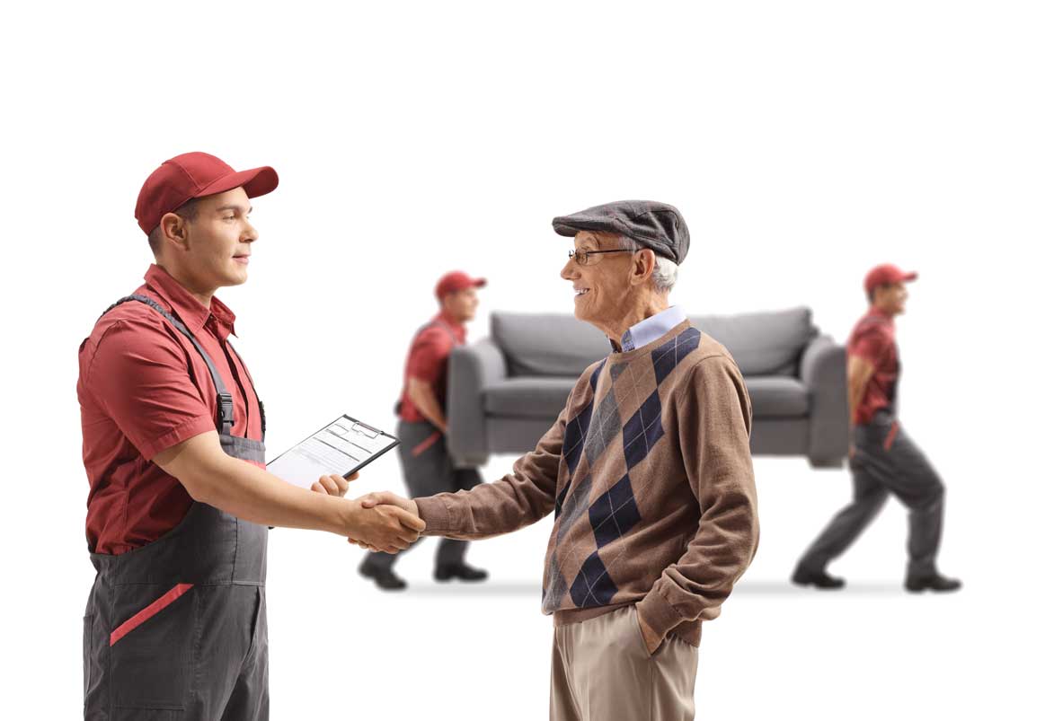 Senior Man Shaking Hands With A Mover, Movers Carrying A Couch In The Back Isolated On White Background